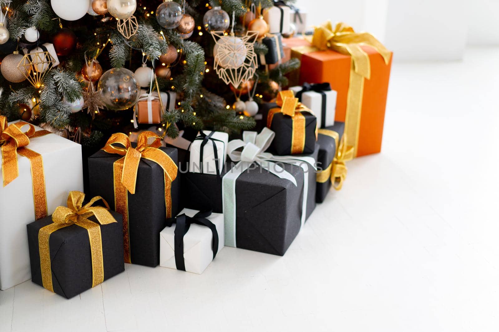 Christmas present box black, orange and white color on white floor with copy space. Holiday gift box