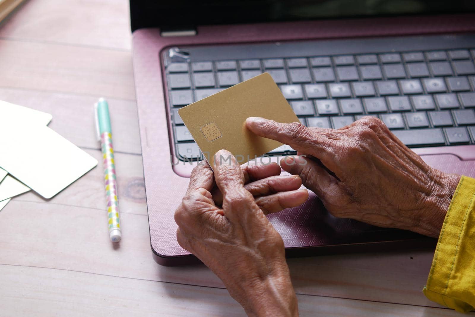 senior women hand holding credit card white sited .