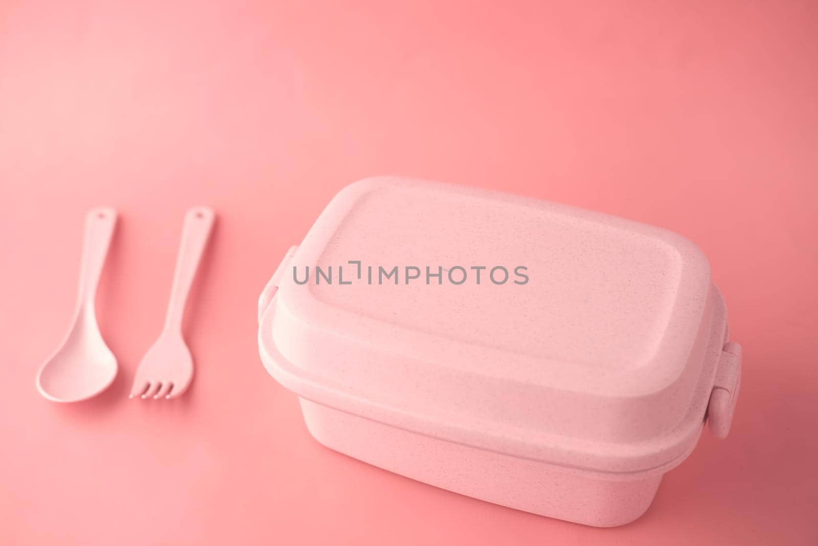 pink color lunch box on color background .