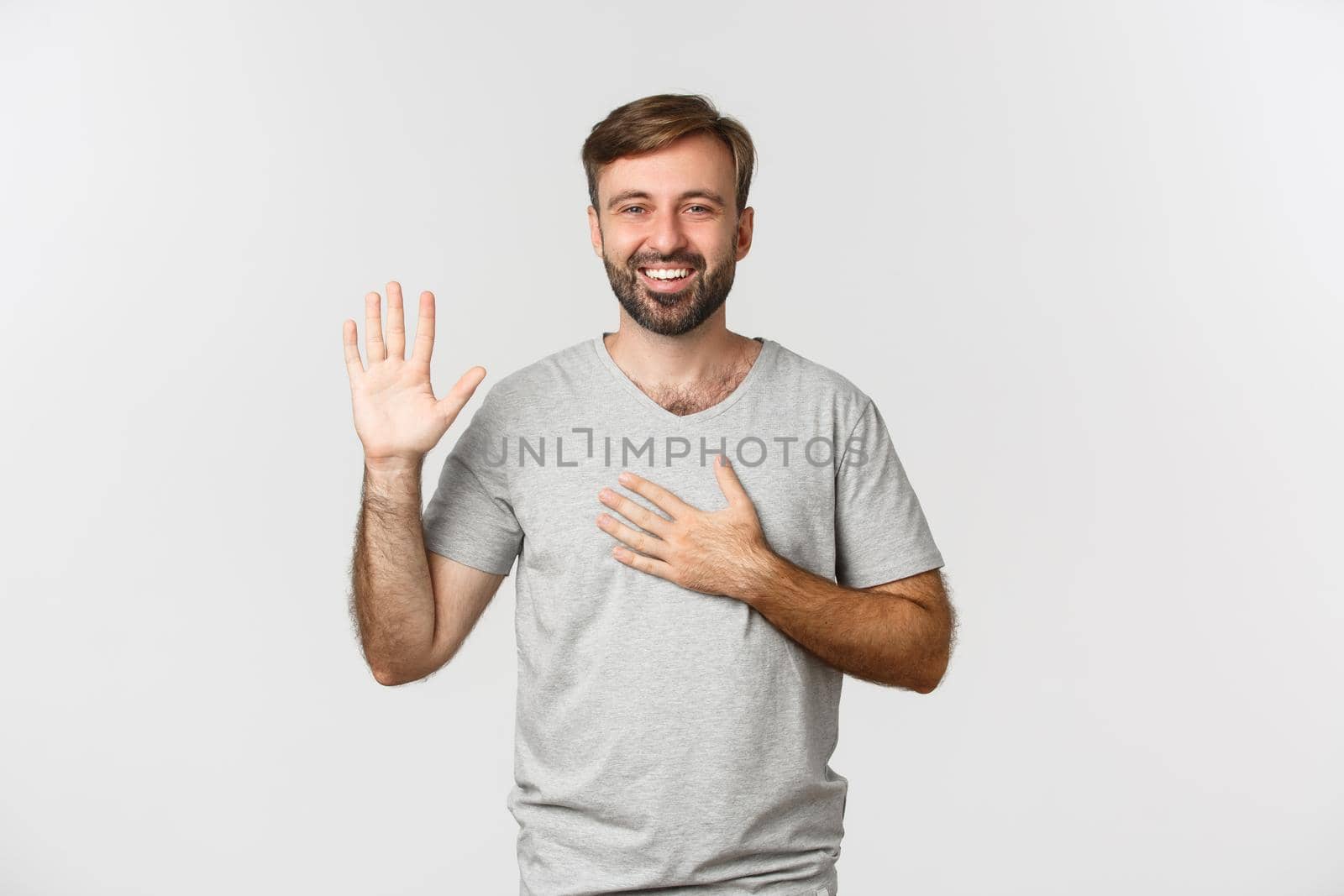 Portrait of sincere handsome guy with beard, making promise, swearing or giving oath, standing over white background by Benzoix