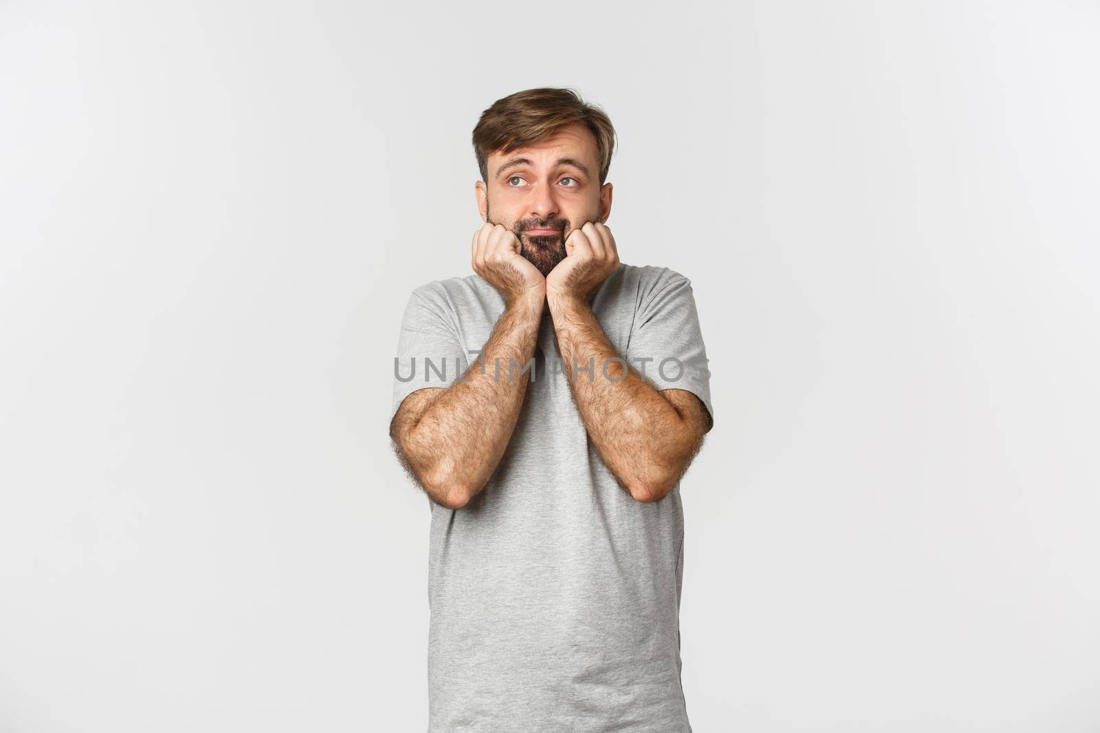 Portrait of gloomy and sad caucasian man looking left with bored expression, standing over white background.