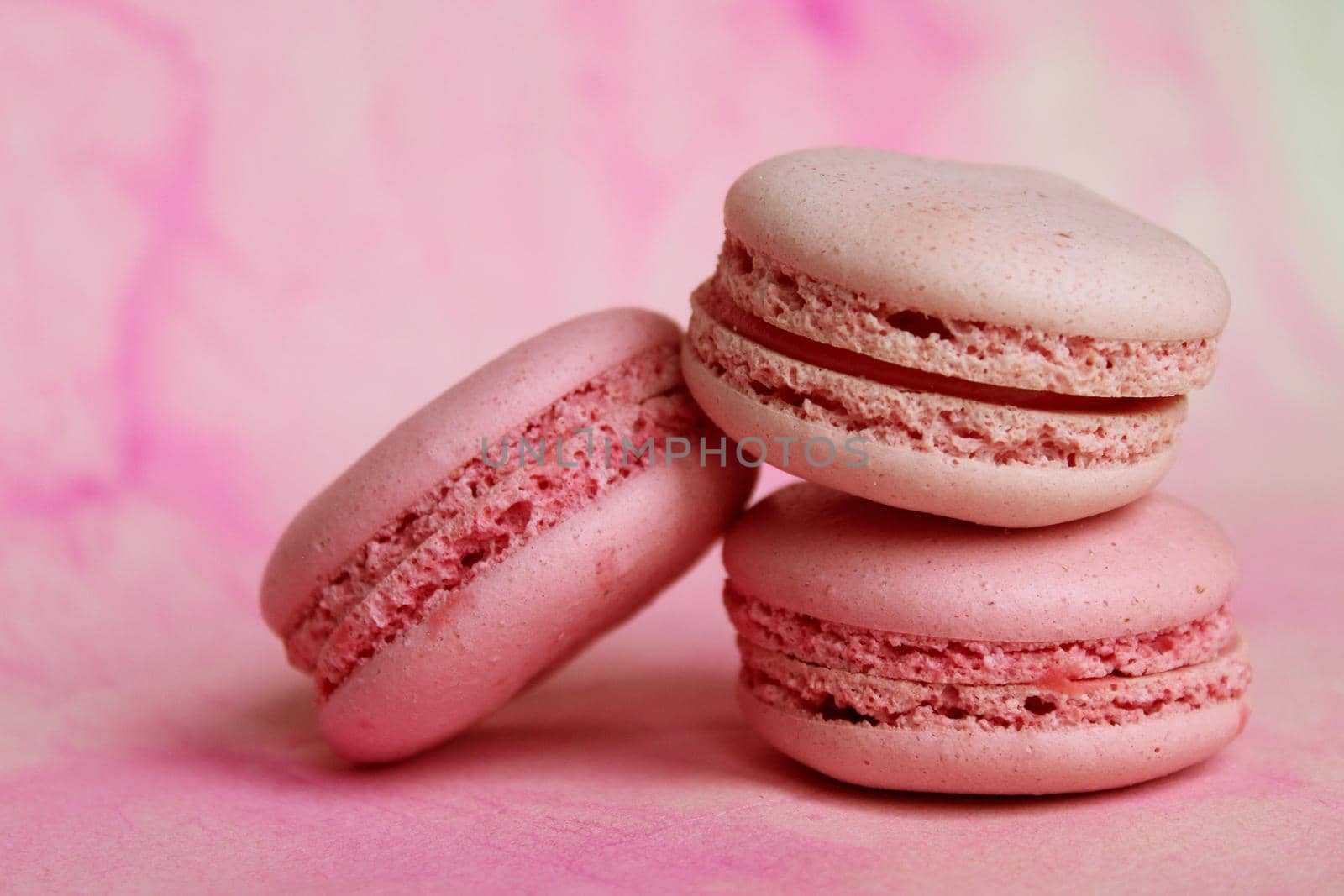 Three pink macaroon cakes on a pink background. Closeup on pink backdrop. Romantic background. Pastel background. Traditional symbol.