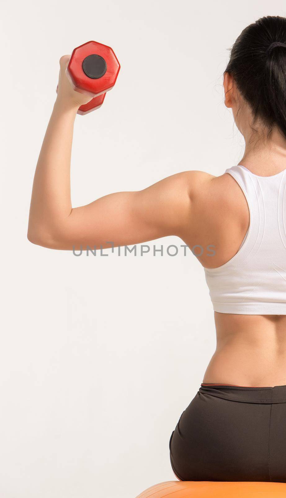 Sports young woman with dumbbells. studio shot. human half