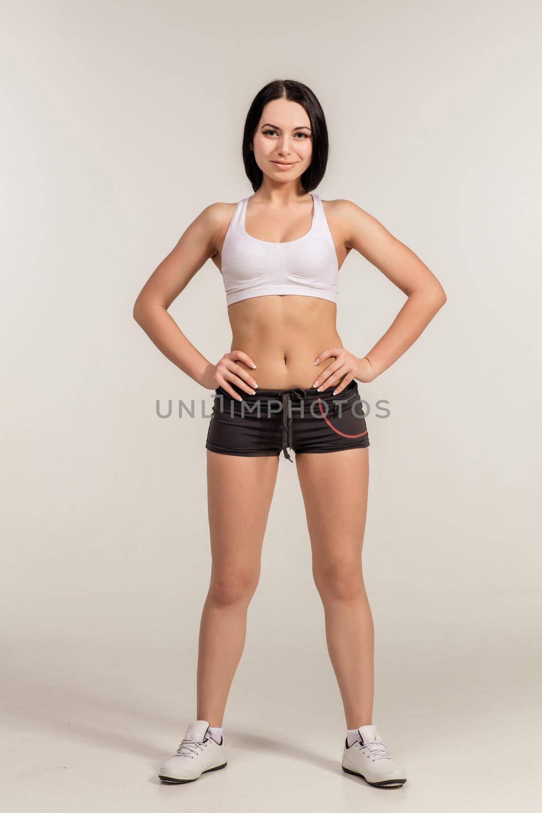 Sports young woman in shorts and top. studio shot. look at the camera