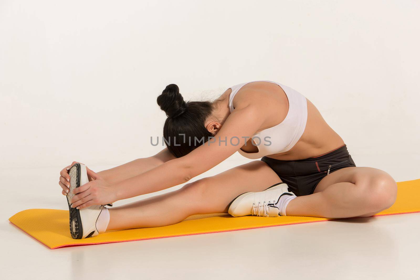Portrait of young attractive woman doing exercises. Brunette with fit body on yoga mat. Healthy lifestyle and sports concept. Series of exercise poses.