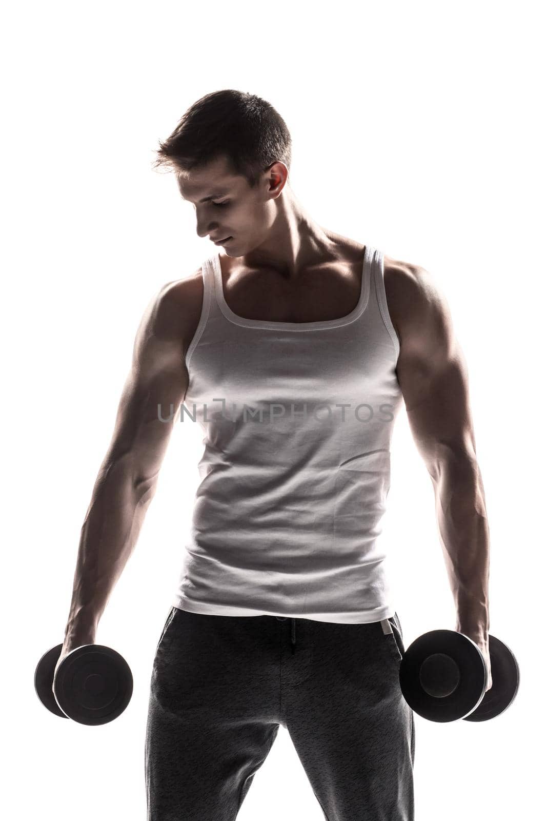 Handsome muscular man with dumbbells looking at the camera, isolated on white background