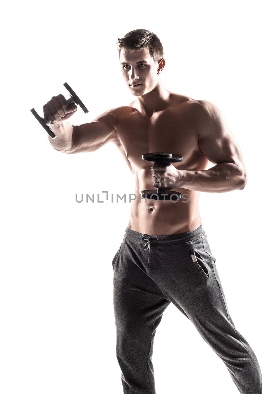 Handsome muscular man doing exercises with dumbbells isolated on white background