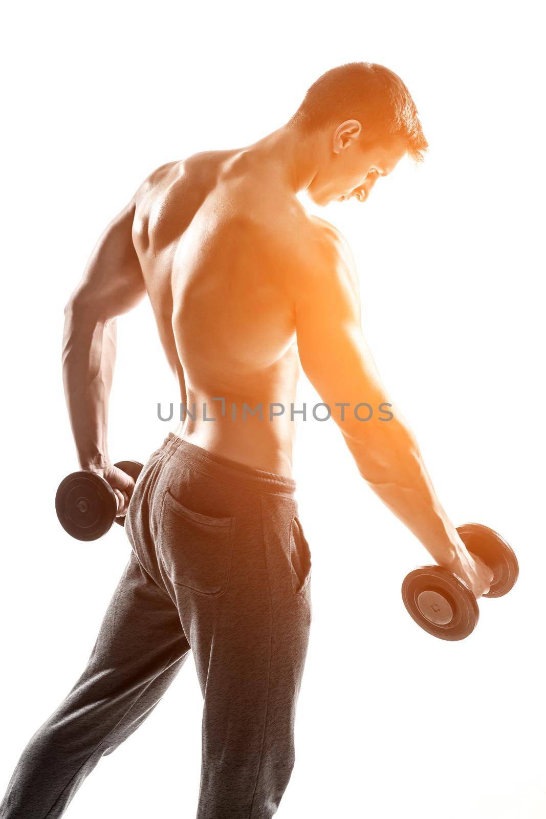 Handsome muscular man doing exercises with dumbbells isolated on white background Whith solar flare