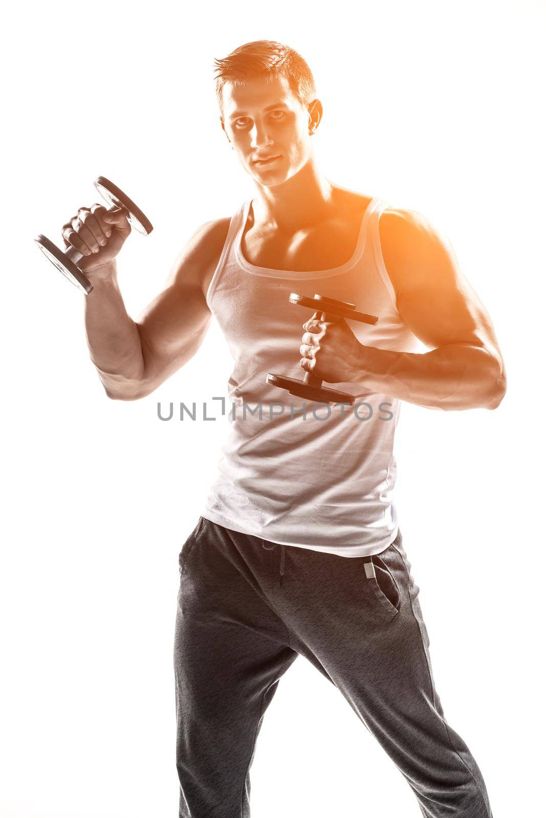 Handsome muscular man doing exercises with dumbbells isolated on white background Whith solar flare