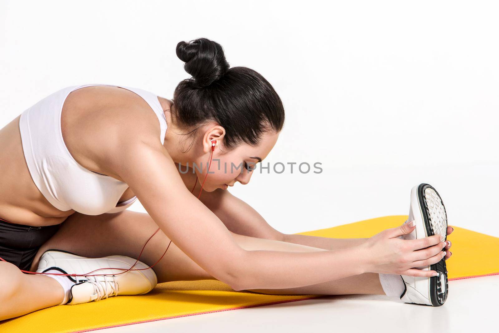 attractive woman doing exercises. Brunette fit body on yoga mat by nazarovsergey