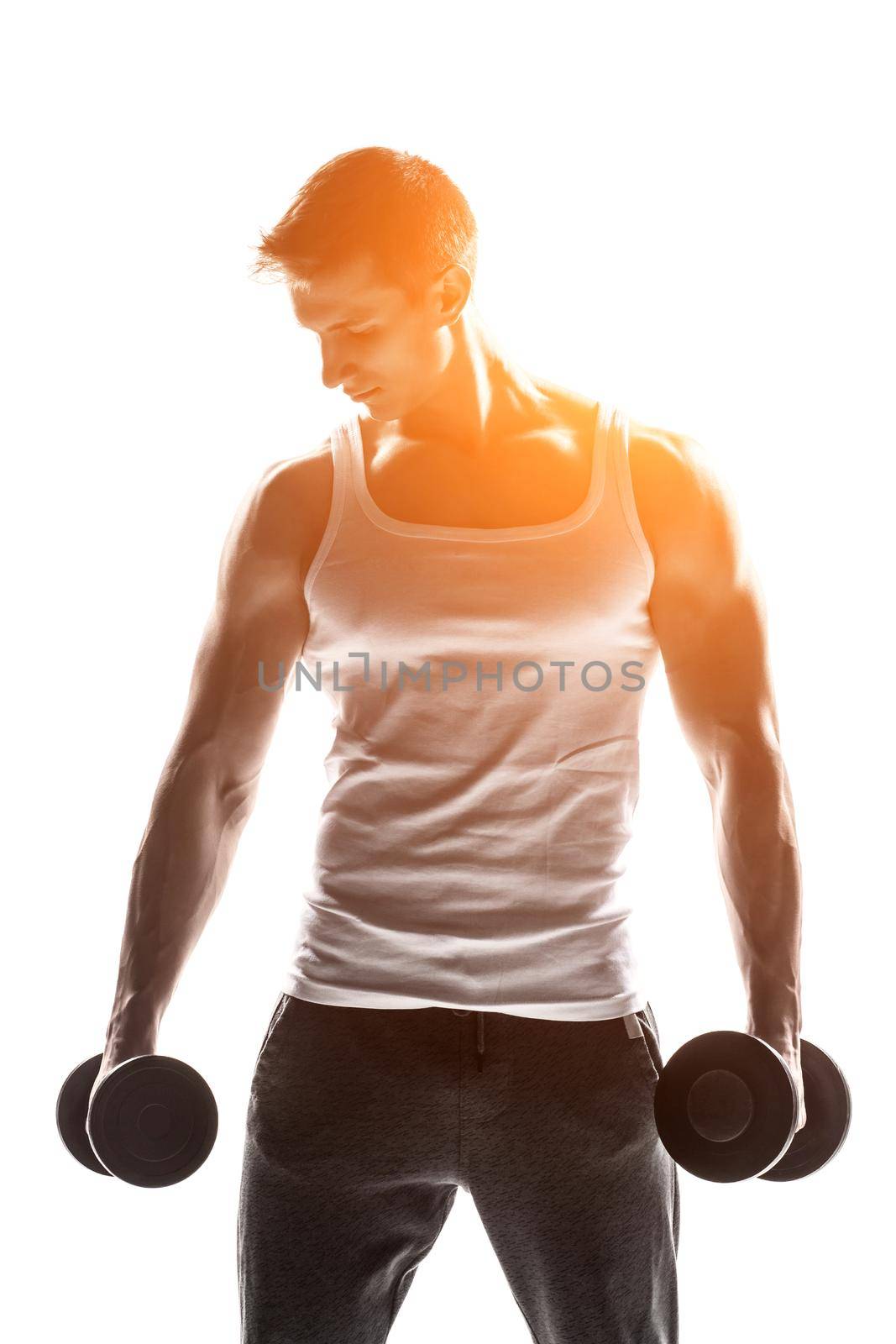 Handsome muscular man with dumbbells looking at the camera, isolated on white background Whith solar flare