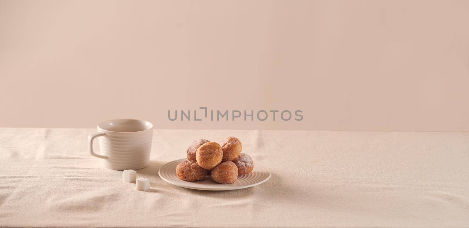 Donuts with sugar on plate and coffee cup on white background by makidotvn