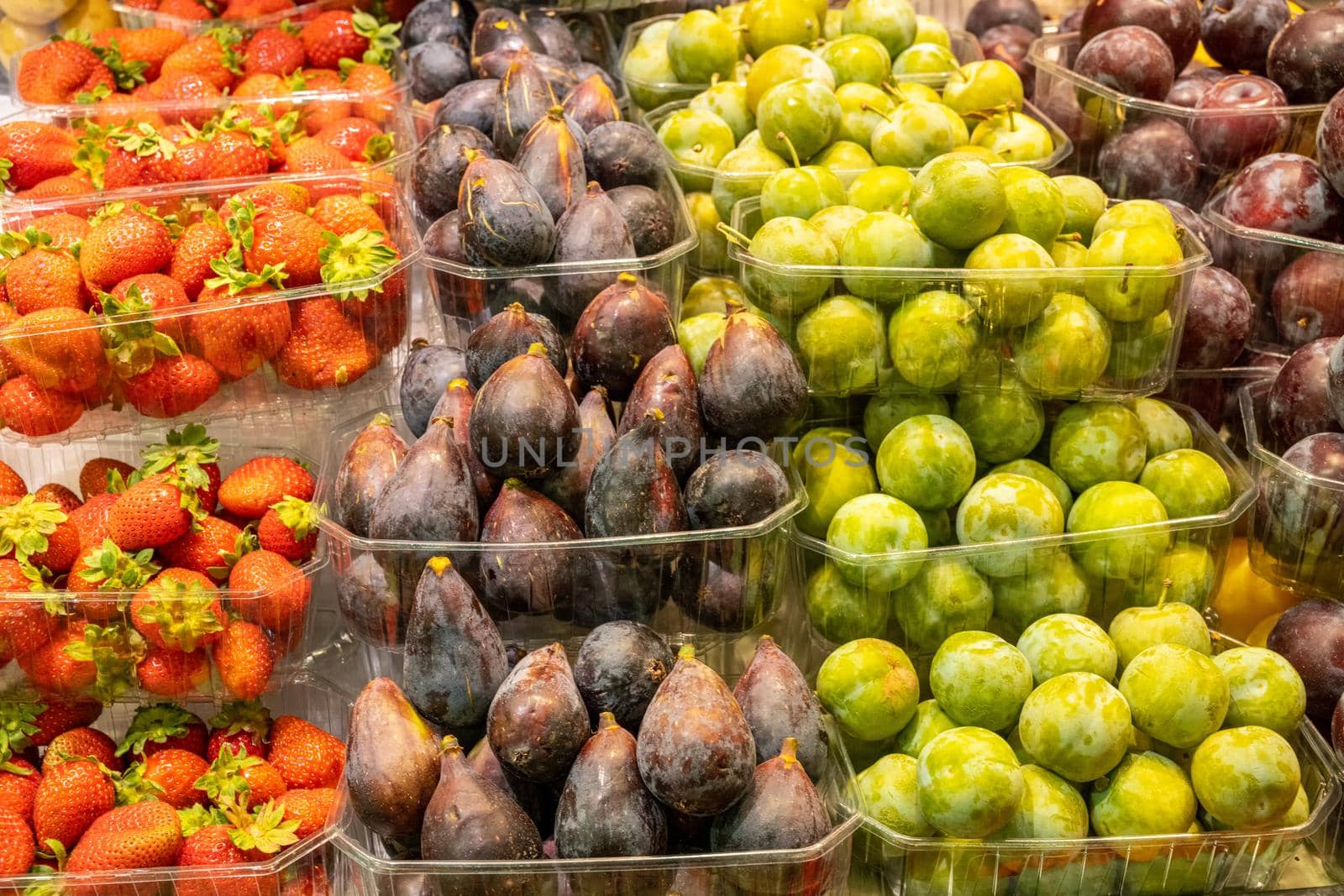 Plums, strawberries and figs for sale at a market