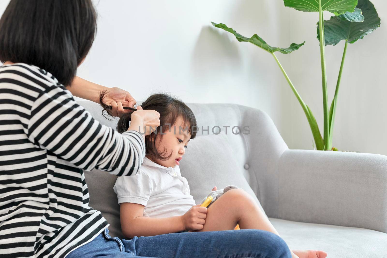 mother braiding hair of her daughter by makidotvn