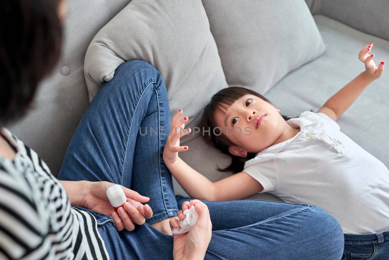 Mother and daughter having fun painting fingernails, family time concept