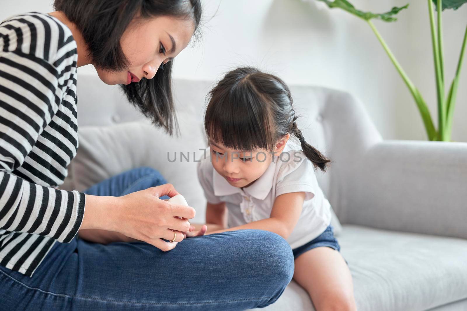 Mother and daughter having fun painting fingernails, family time concept by makidotvn