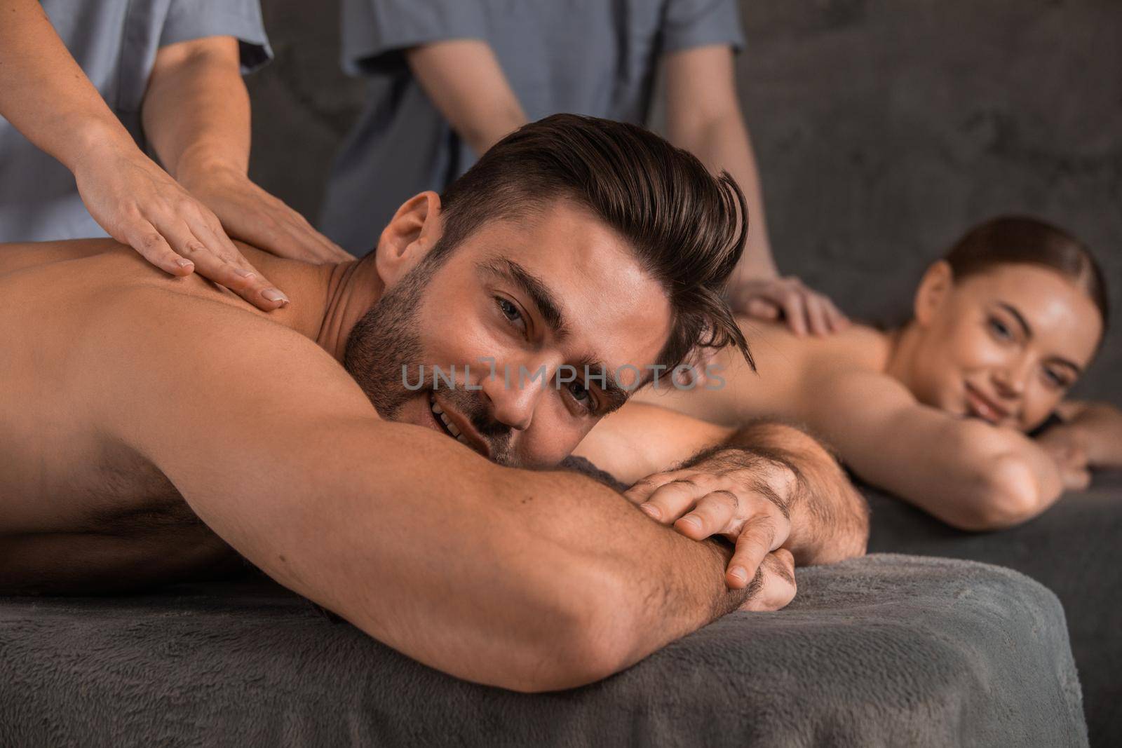 Beautiful young couple enjoy together a massage at spa centre