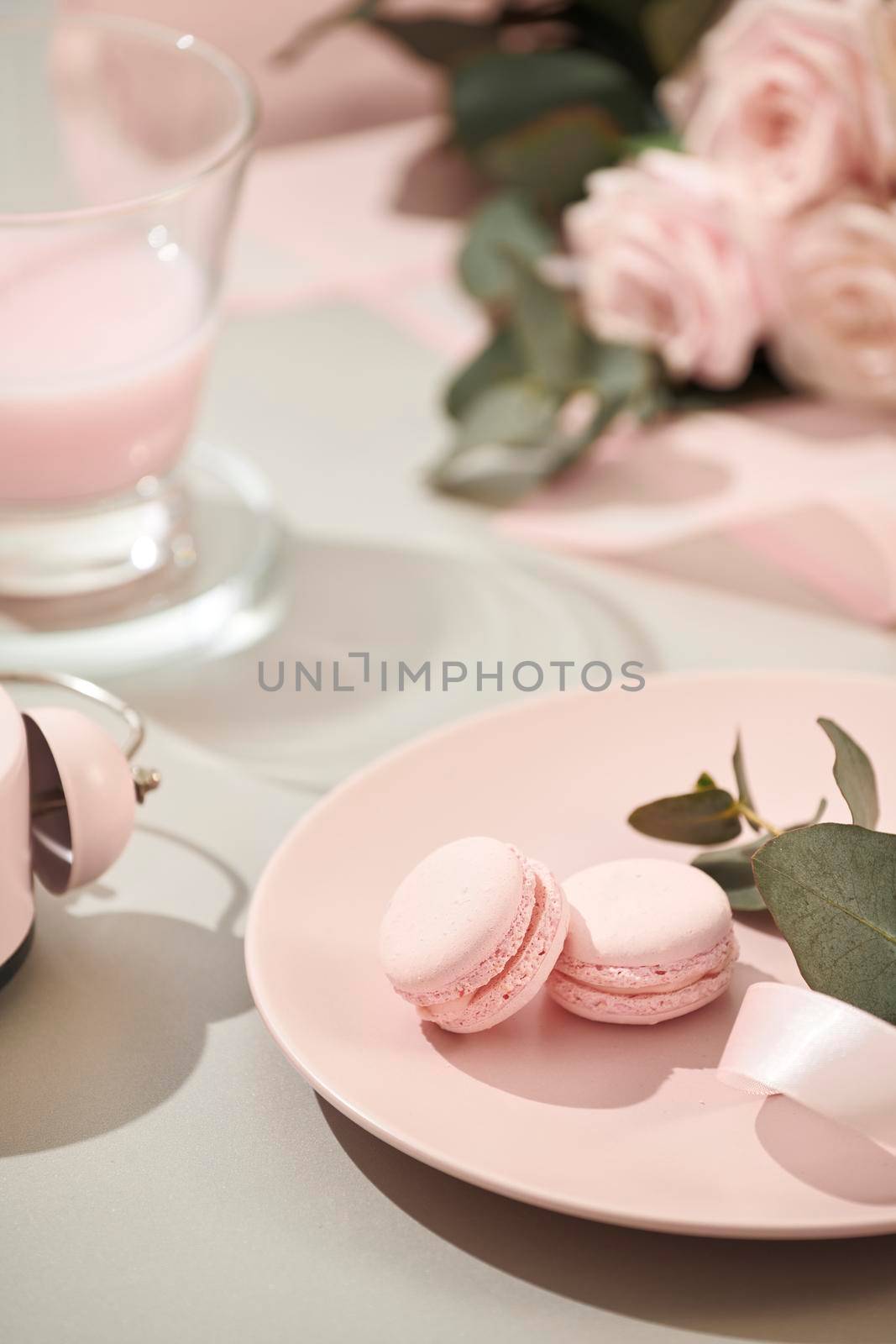 macaroons in pastel colors with bouquet of pink roses flowers on white background. Beautiful holiday background. copy space. by makidotvn