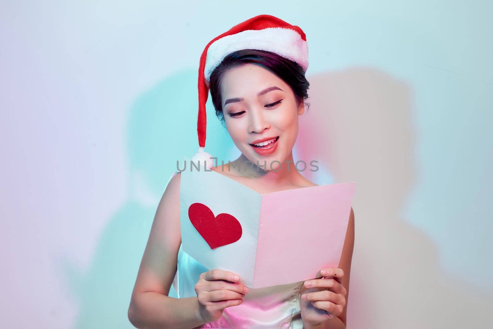Image of happy beautiful female reading romantic postcard with big red heart, attractive woman got sensual greeting card and isolated on white background, Valentine day, love concept by makidotvn