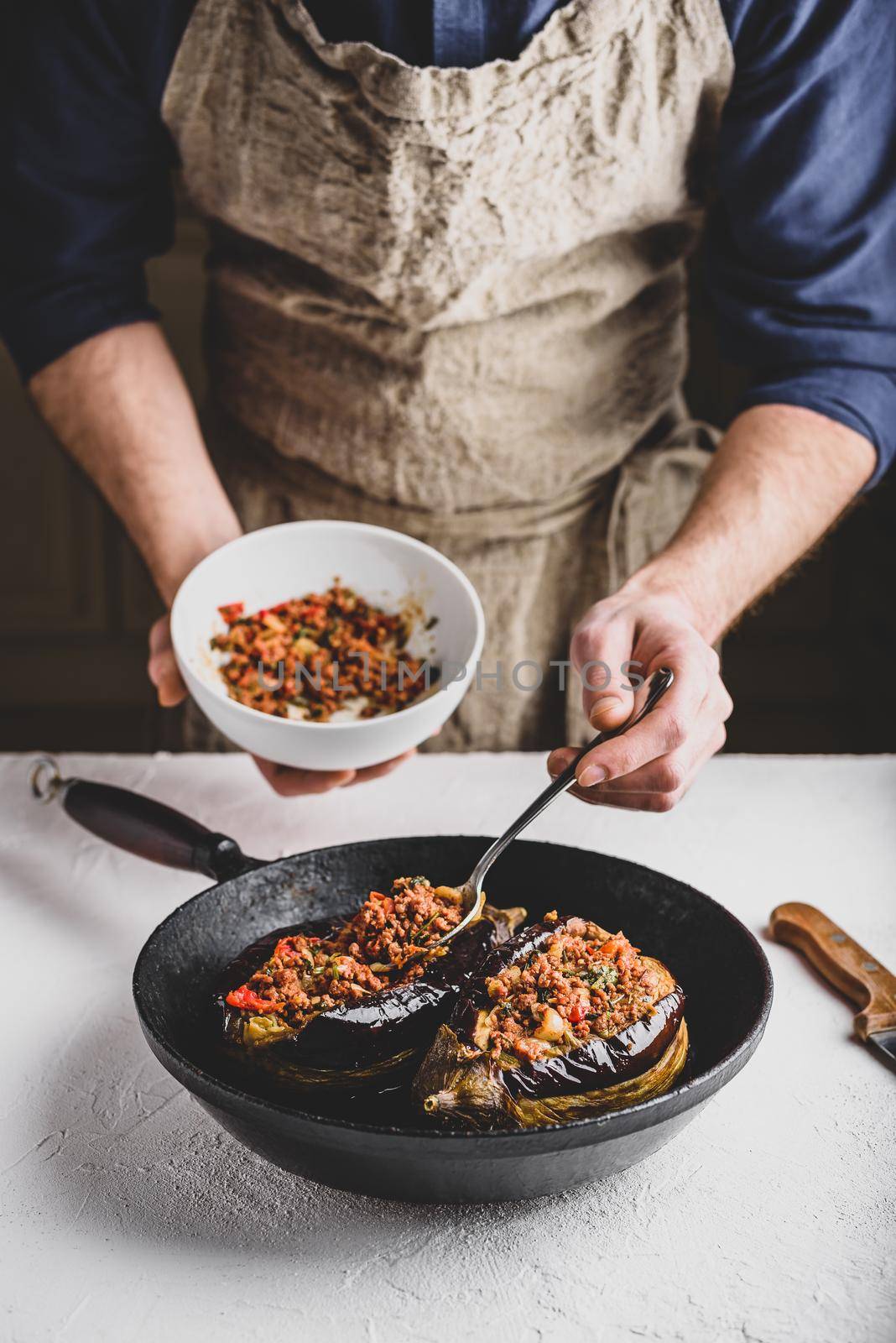 Preparing eggplants stuffed with ground beef, tomatoes and spices by Seva_blsv