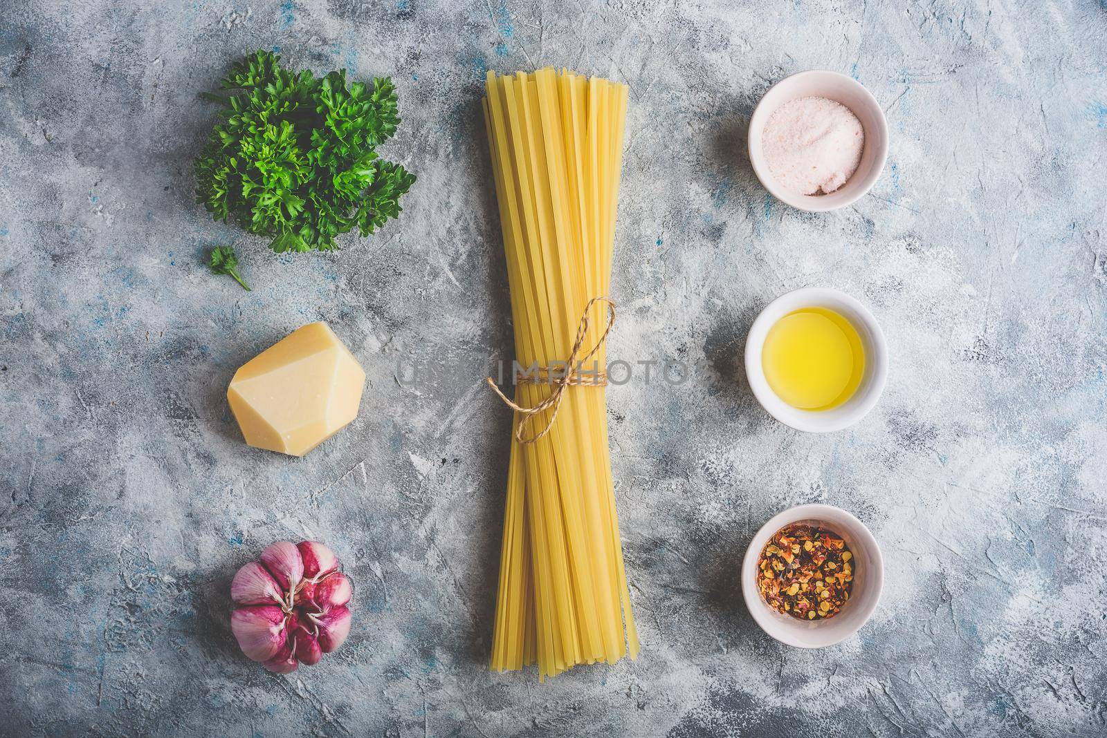 Raw ingredients for cooking linguine with olive oil, garlic and parsley. View from above