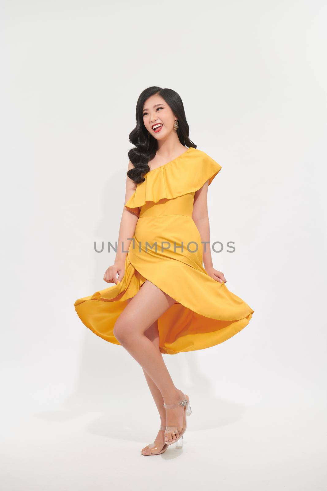 beautiful asian women swirling with happiness, in pretty yellow dress by makidotvn