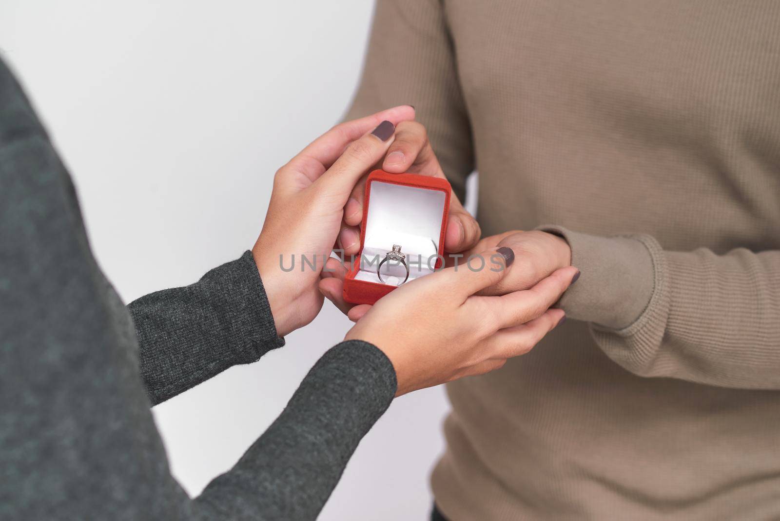 Asian man gives wedding ring and gift box to his woman by makidotvn