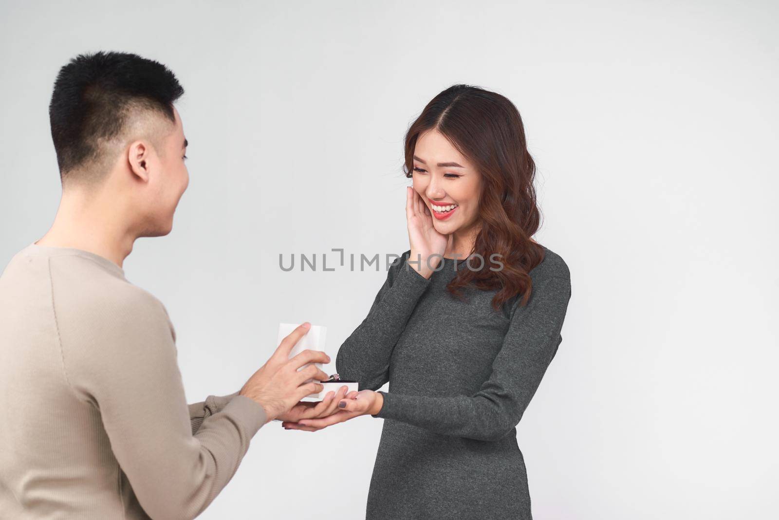 Asian man gives wedding ring and gift box to his woman by makidotvn