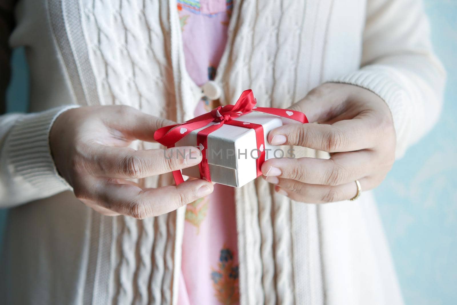 women hand holding small heart shape gift box .