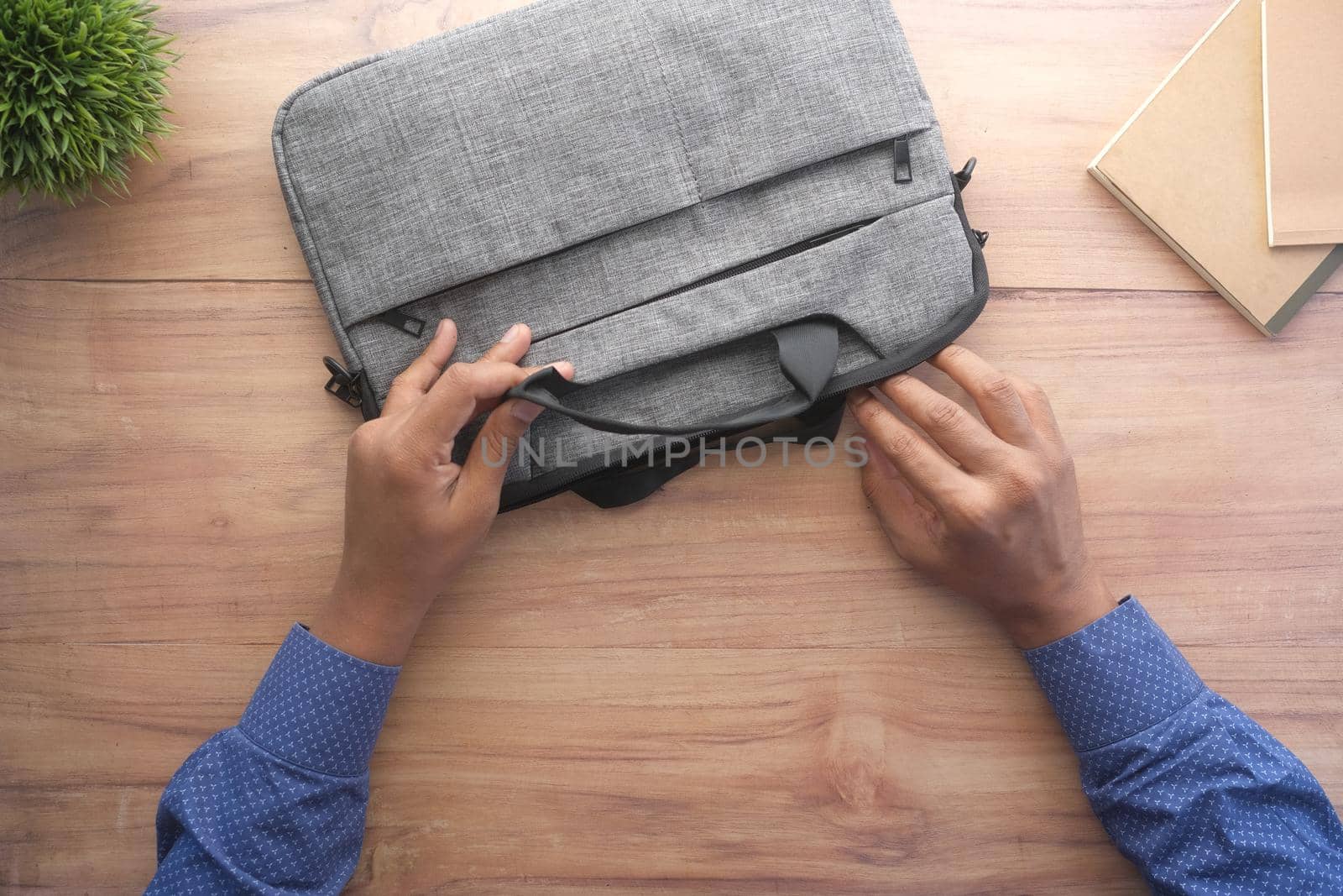 young man searching something in a shoulder bag .