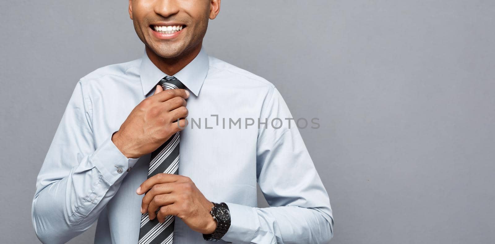 Business Concept - Happy confident professional african american businessman posing over grey background