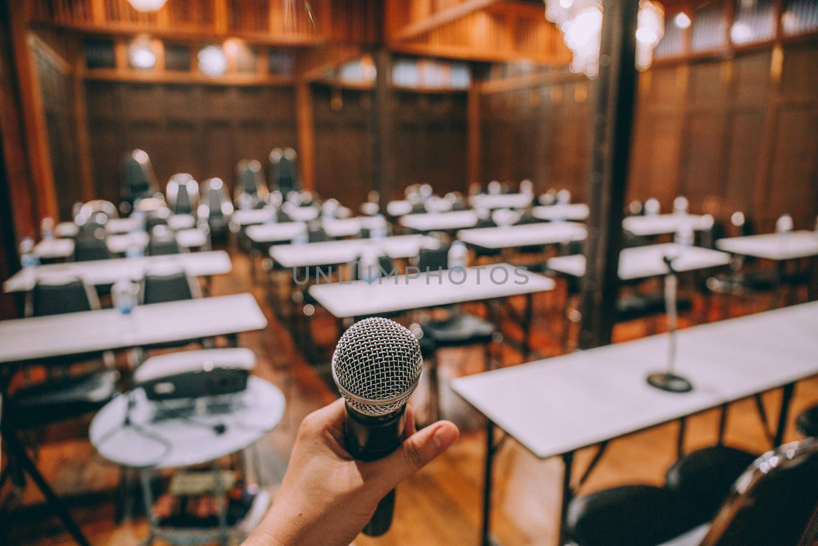 Close-up microphone with blurred people attending seminar background