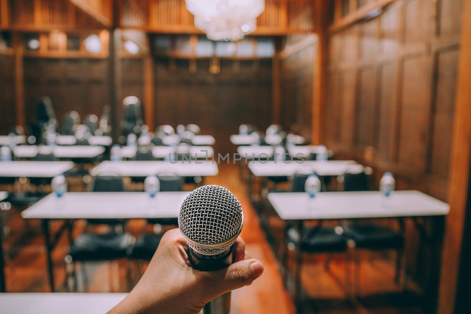 Close-up microphone with blurred people attending seminar background