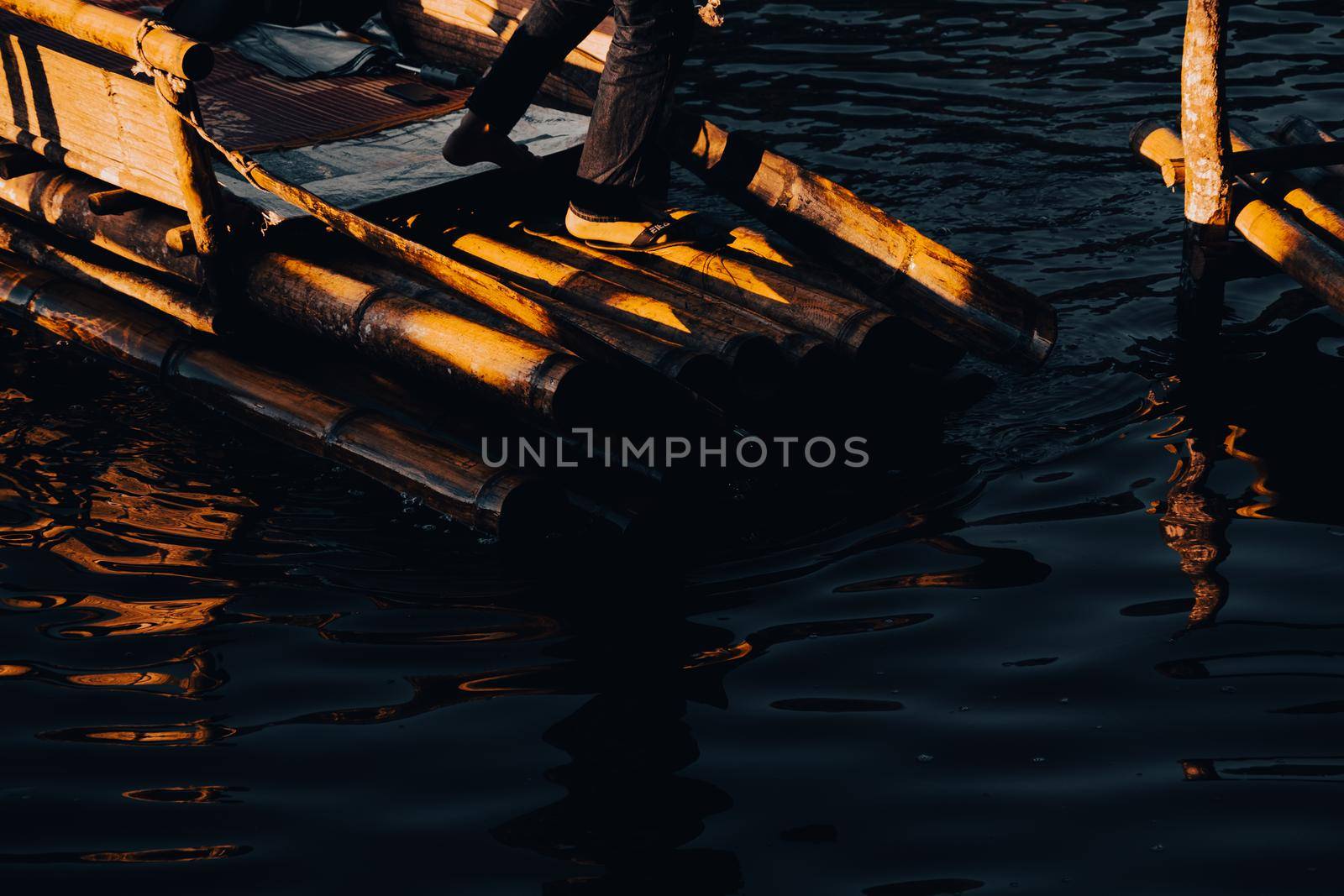 Mae Hong Sorn, Thailand - December 17, 2021 : Beautiful lake over the misty river at sunrise with traveler on the Bamboo raft. Morning view at Pang Oung Lake (Pang Tong reservoir), Mae hong son, Thail by TEERASAK