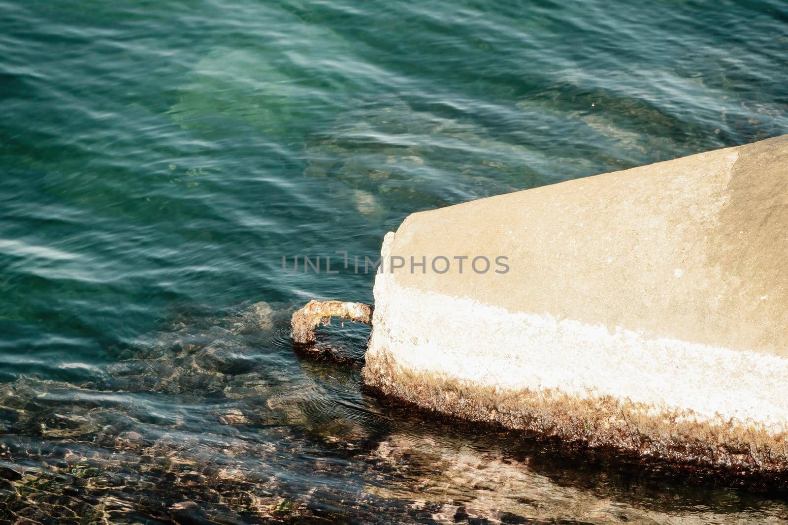 The seashore is reinforced with concrete tetrapods. Protection of the shore from blurring. Sea waves. Concrete tetrapod breakwaters lie all along the coast.