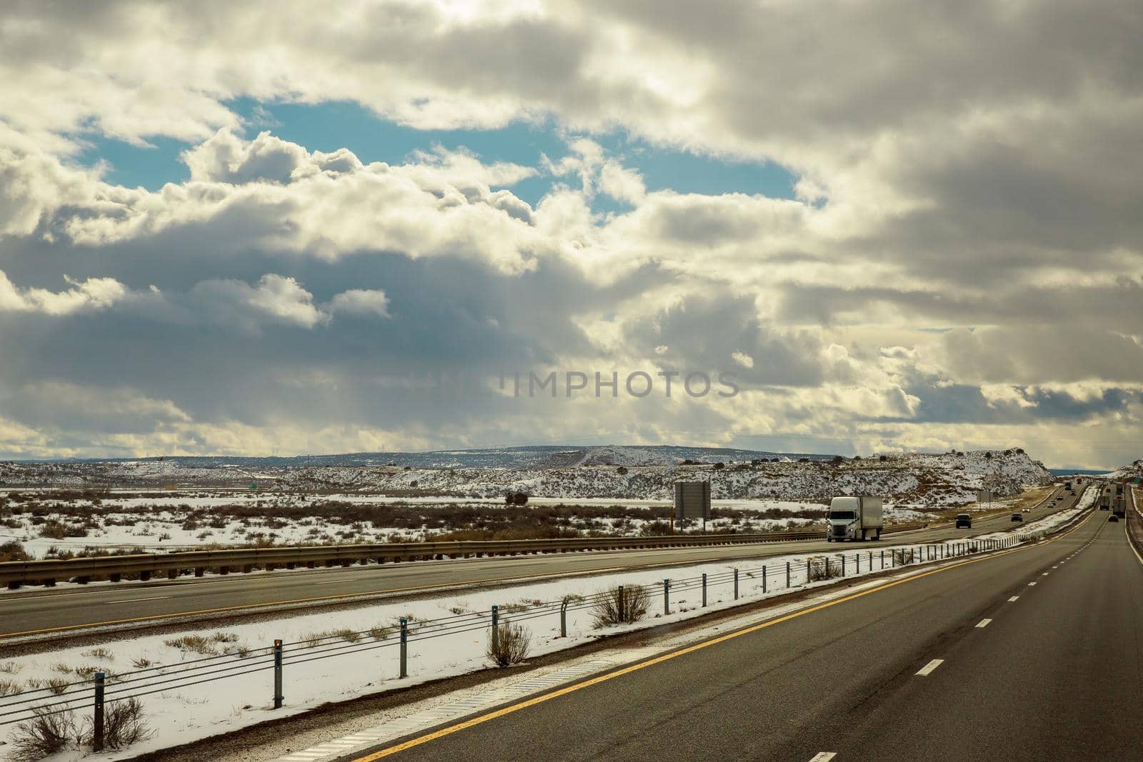 Mountain with snow covered of desert rocks along I-40 highway in winter New Mexico by ungvar