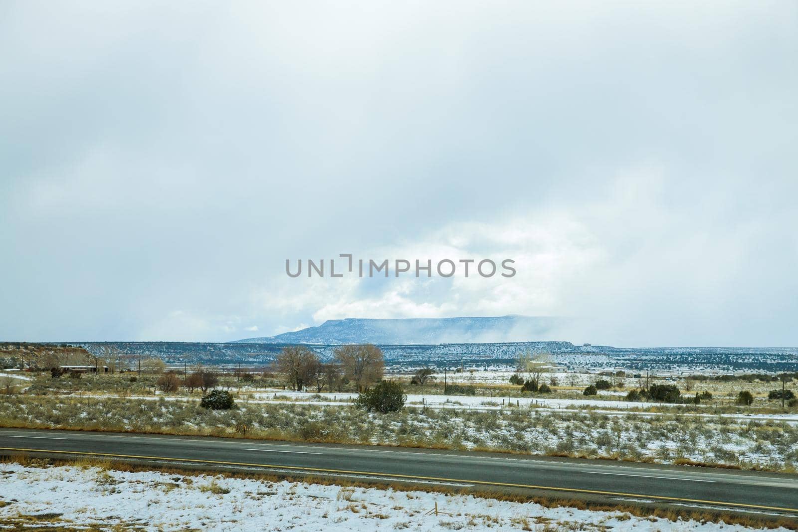 Mountain with snow covered of desert rocks along I-40 highway in winter New Mexico US