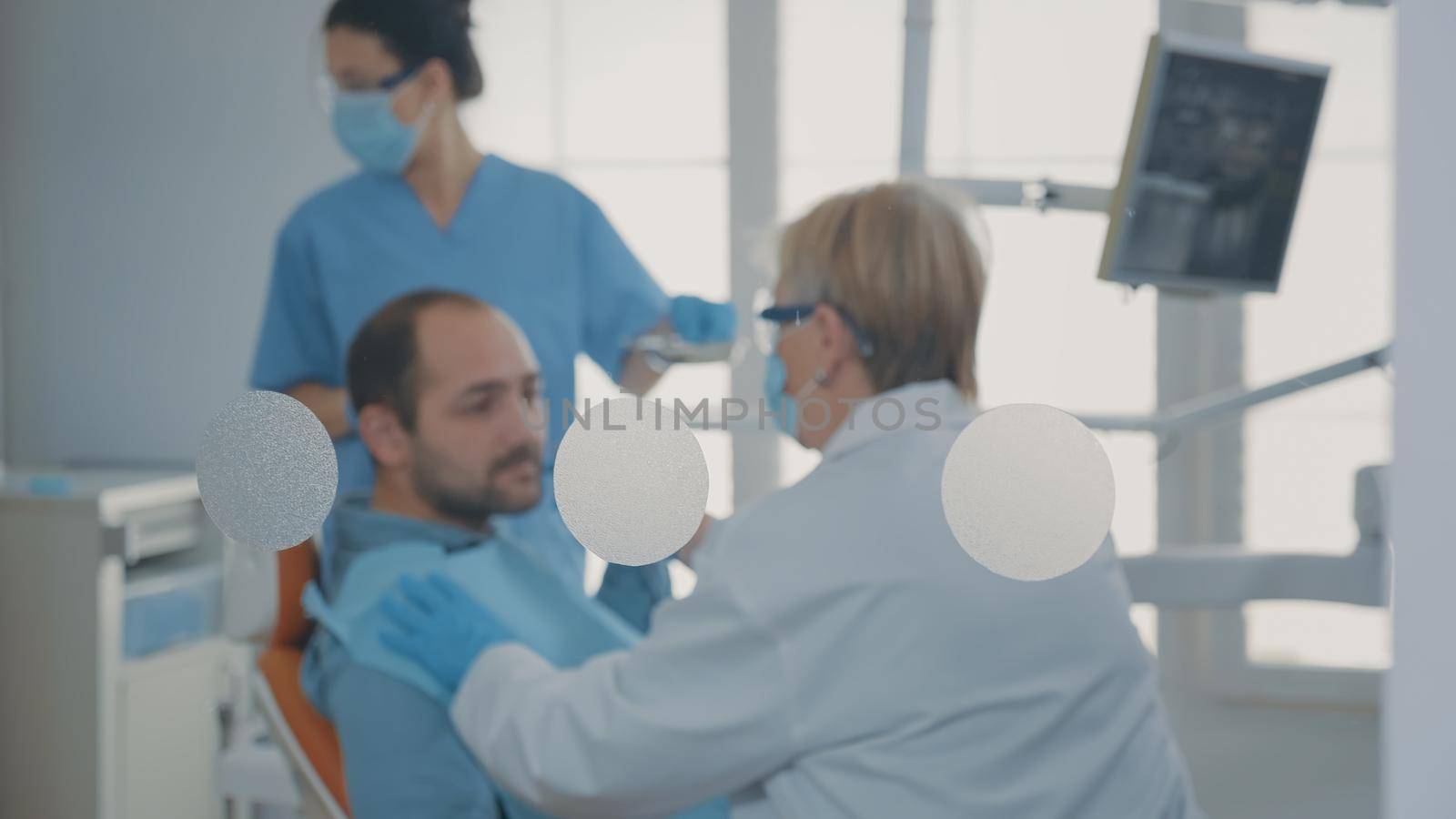 Specialist examining patient with denture problems and caries by DCStudio