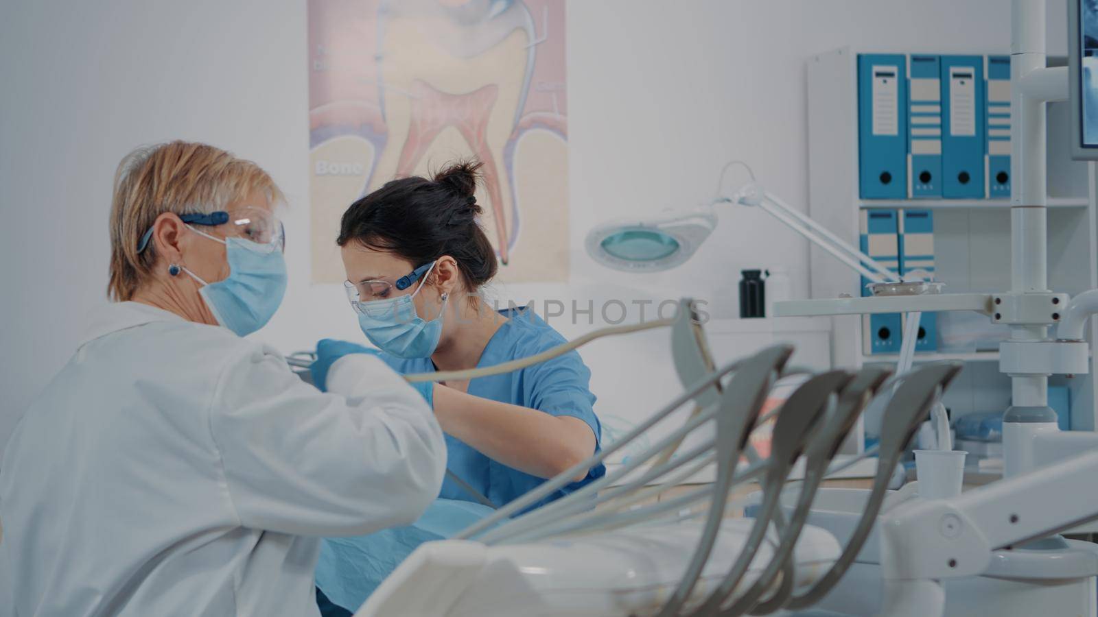 Nurse and stomatologist examining teeth of patient by DCStudio