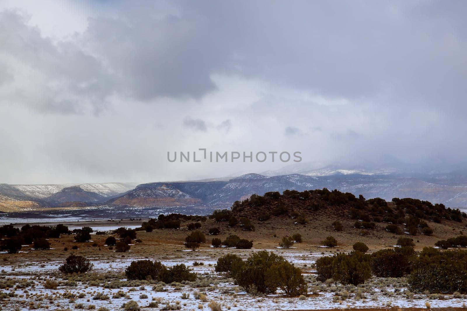 Scenic snow covered of desert mountain along I-40 highway with asphalt road in winter New Mexico by ungvar
