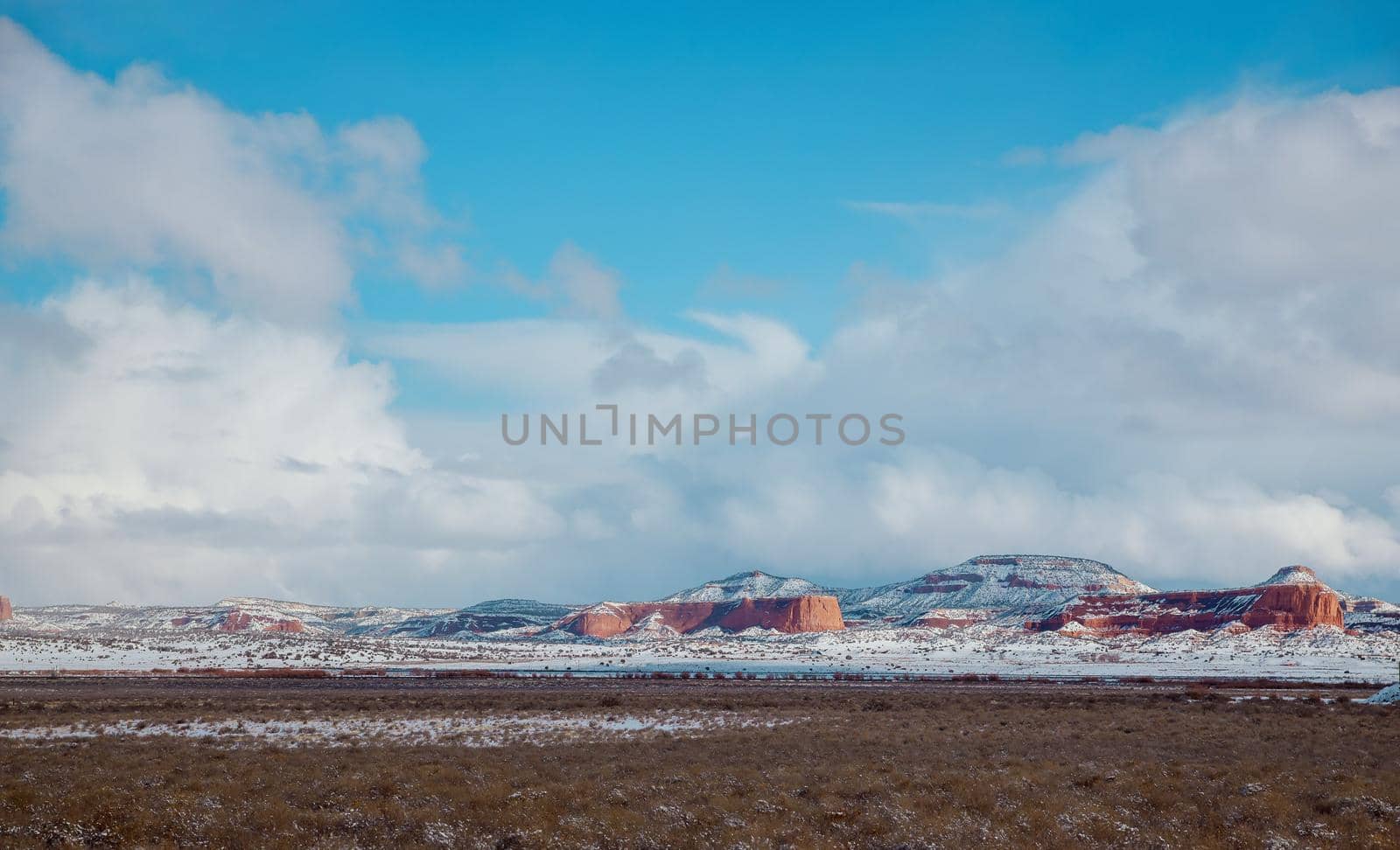 Dangerous covered roads and hazardous winter weather along a high rocky mountains I-40 road with winter snow covered landscape in the New Mexico by ungvar