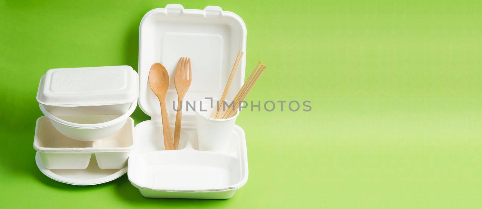 The Eco friendly biodegradable paper disposable for packaging food and paper glass on green background.