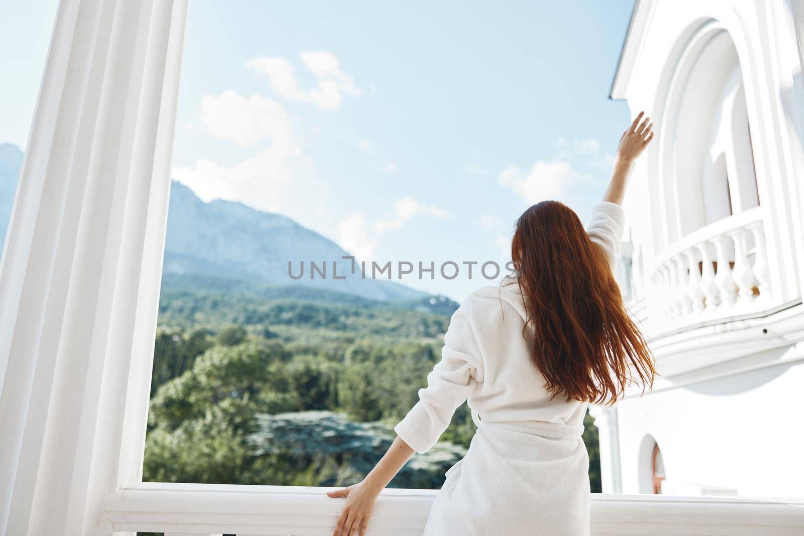 woman white robe admire the view from the window back view. High quality photo
