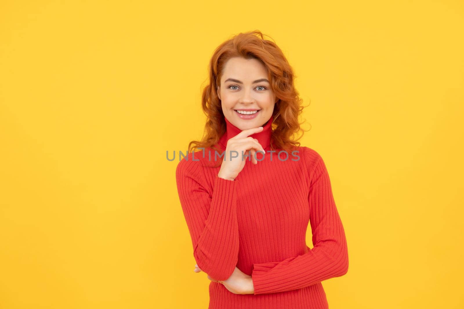 woman face. Close up Portrait of beautiful cheerful redhead girl curly hair smiling laughing looking at camera over yellow background