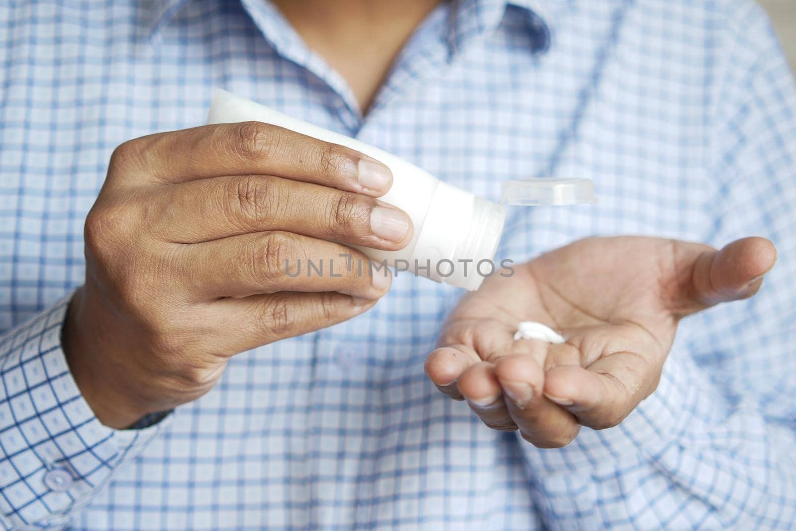 man applying beauty cream onto skin .