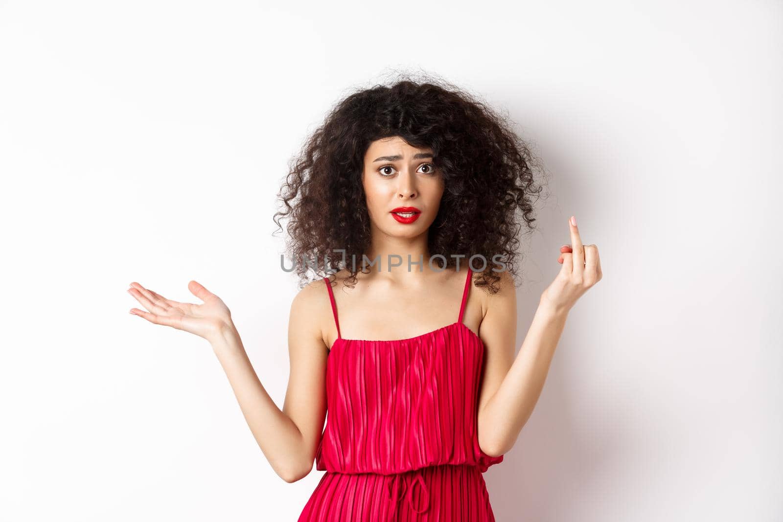 Annoyed caucasian woman in red dress, showing finger without wedding ring, arguing about marriage, standing pissed-off on white background.