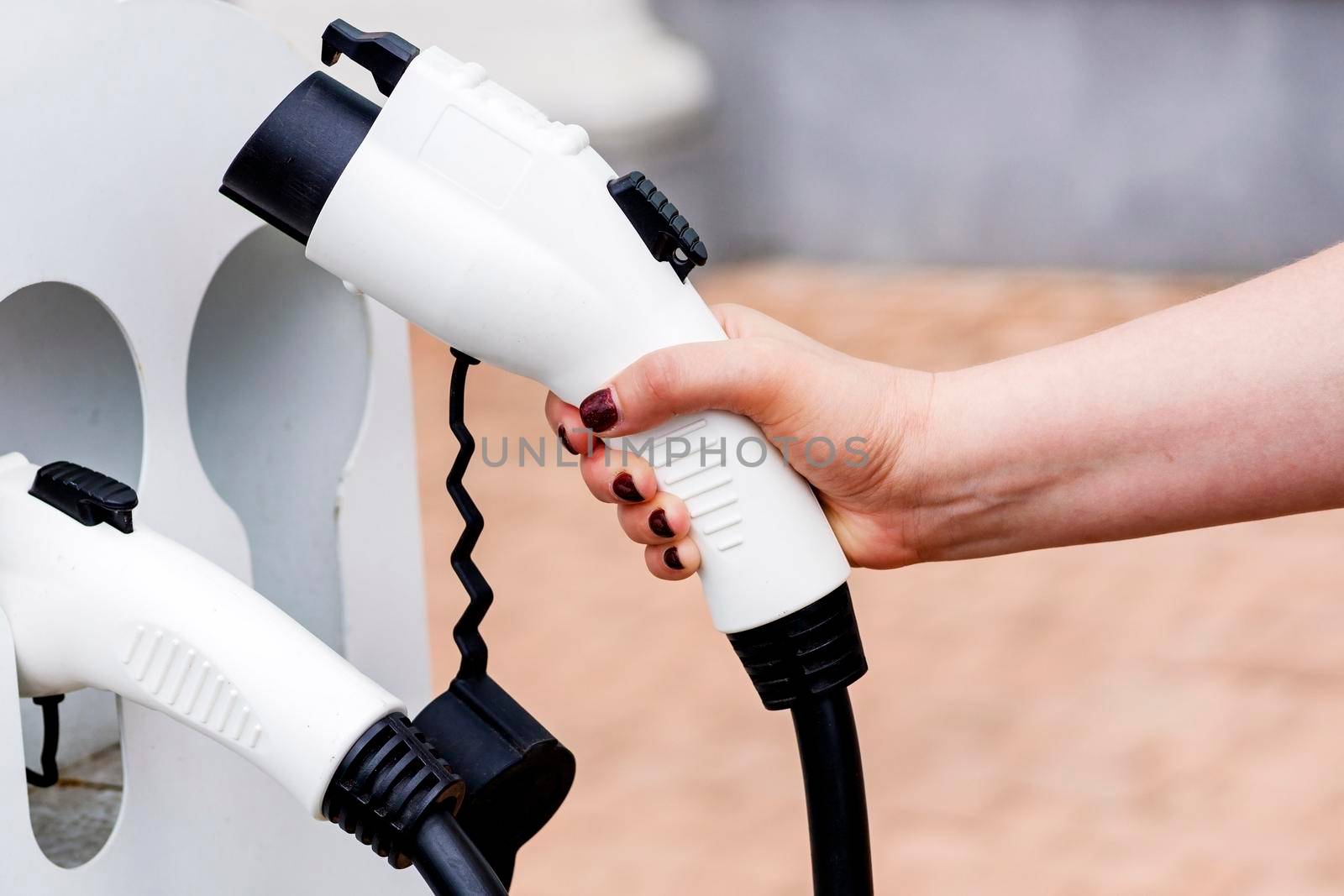  female hand takes an charging cable. driver picks up a cable by BALKON