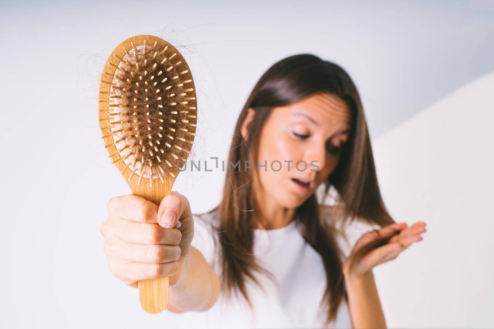 Woman with hair brush with damaged hair. Hair loss problem. Bad hair falling out by DariaKulkova
