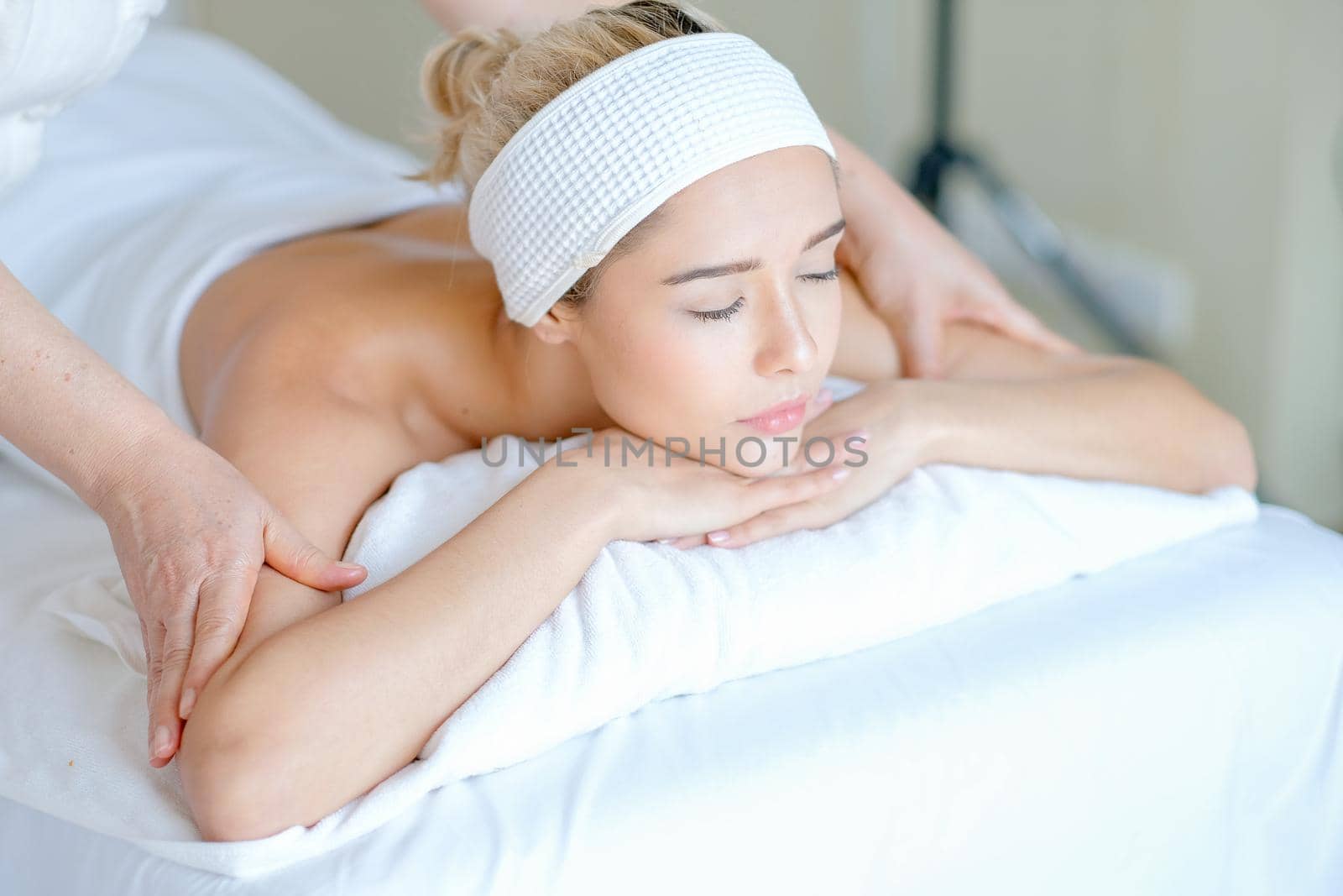 Young woman enjoy with massage in spa room with day light.