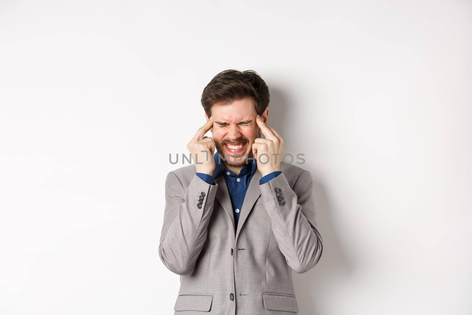 Image of frustrated man trying to think, cant remember something, touching head temples and squinting with tensed grimace, brainstorming, searching solution, white background.